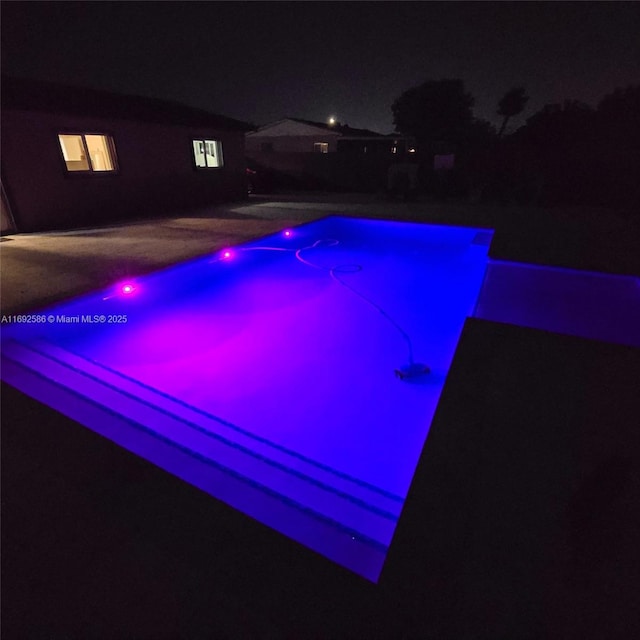 view of pool at twilight