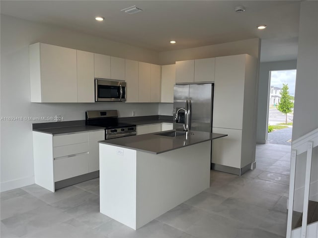 kitchen with a center island with sink, sink, appliances with stainless steel finishes, and white cabinets