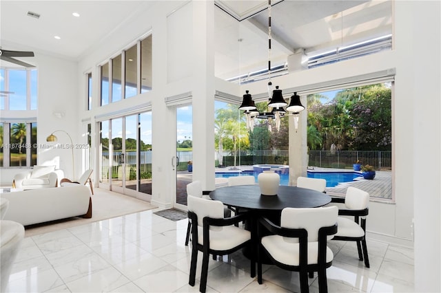 sunroom / solarium featuring a healthy amount of sunlight, a water view, and visible vents