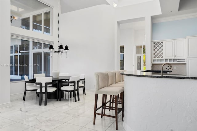 dining space featuring a wealth of natural light, crown molding, and an inviting chandelier