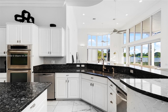 kitchen featuring a healthy amount of sunlight, sink, and dark stone counters