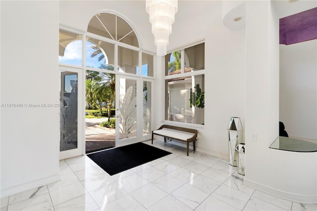 entryway with baseboards, a high ceiling, and marble finish floor
