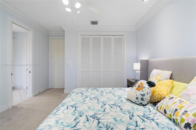 bedroom with light colored carpet, a closet, ornamental molding, and ceiling fan