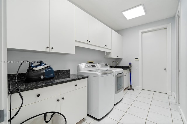 washroom featuring cabinet space, baseboards, light tile patterned floors, and washing machine and clothes dryer