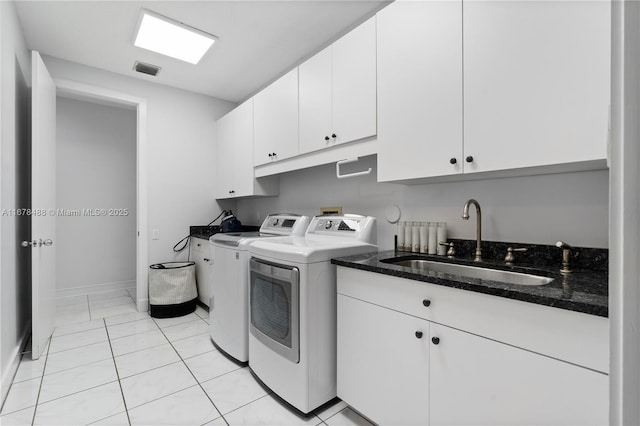 laundry room featuring cabinet space, a sink, baseboards, visible vents, and washer and clothes dryer