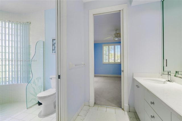 bathroom with ceiling fan, tile patterned flooring, tiled shower, toilet, and vanity