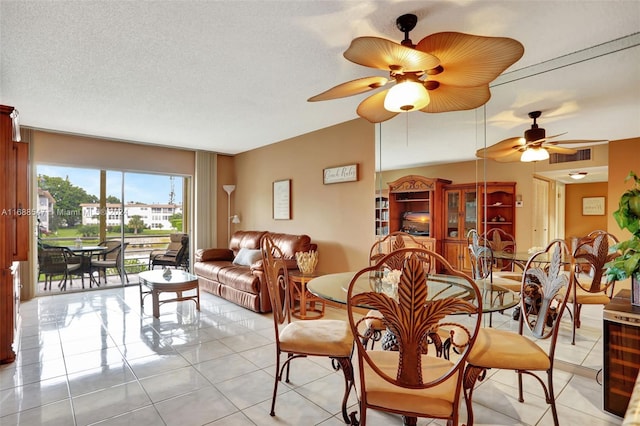 dining space with ceiling fan, light tile patterned floors, and a textured ceiling