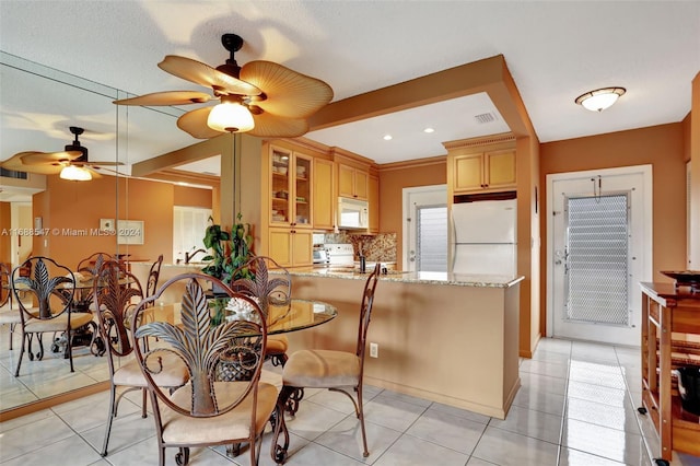 tiled dining room with ceiling fan and a textured ceiling