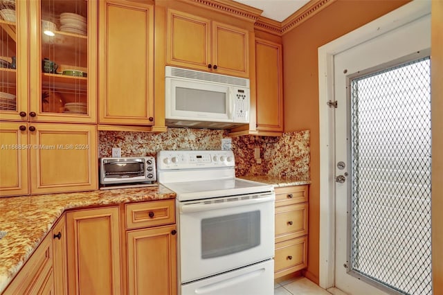 kitchen featuring white appliances, backsplash, light tile patterned floors, and light stone counters