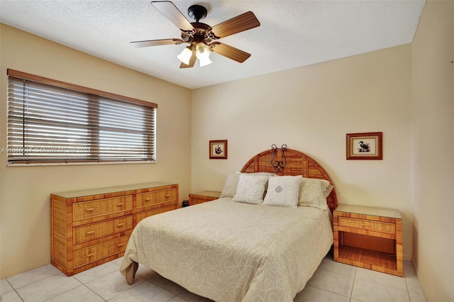 tiled bedroom featuring a textured ceiling and ceiling fan