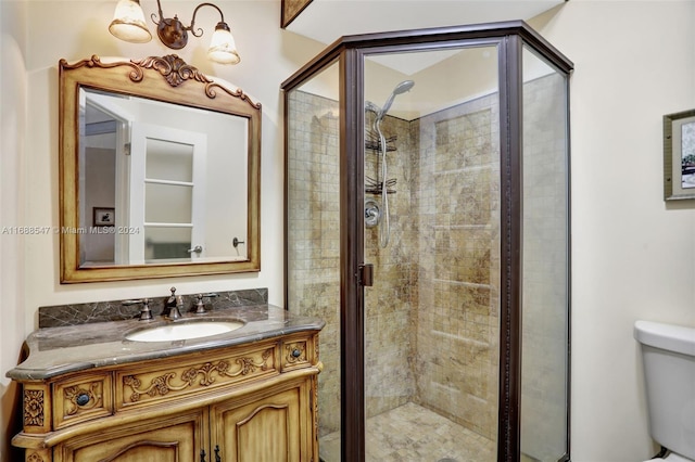 bathroom featuring toilet, vanity, and walk in shower