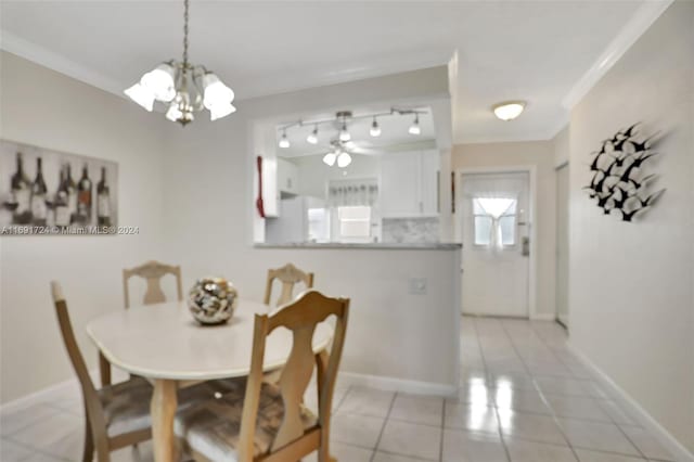 dining space featuring a chandelier, light tile patterned floors, and crown molding