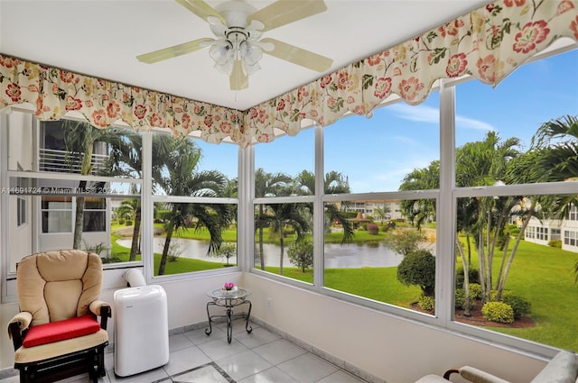 sunroom / solarium featuring a water view and ceiling fan