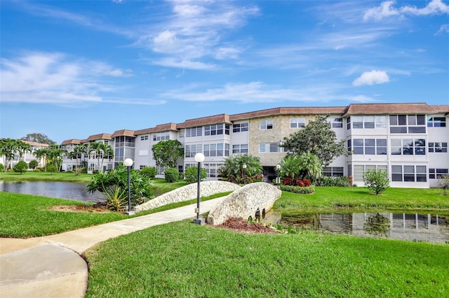 view of home's community featuring a water view and a lawn