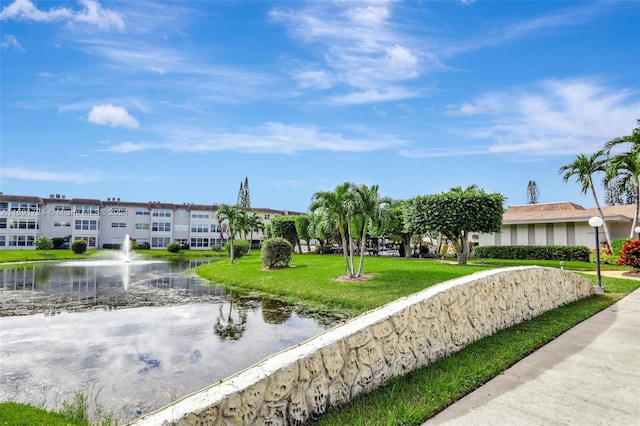 view of home's community with a yard and a water view