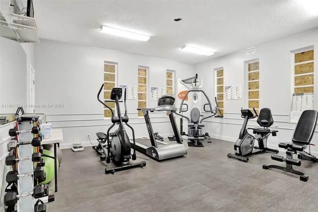 3501 NW 47th Ave Unit 515, Lauderdale Lakes, FL 33319 - exercise room featuring a textured ceiling and baseboards