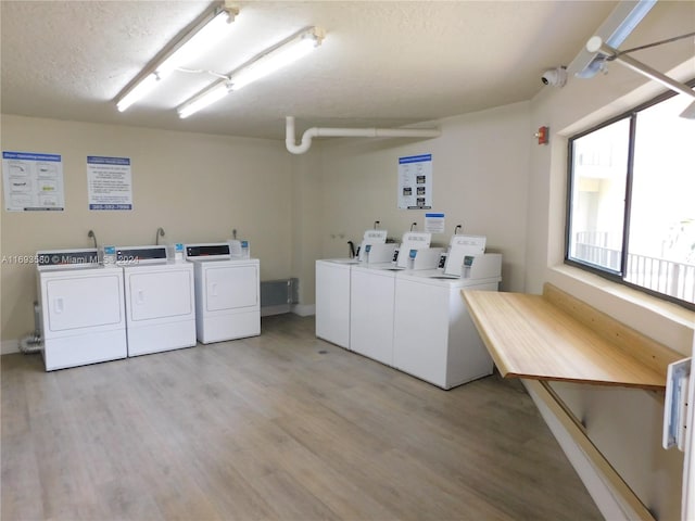 laundry area with separate washer and dryer, hardwood / wood-style floors, and a textured ceiling