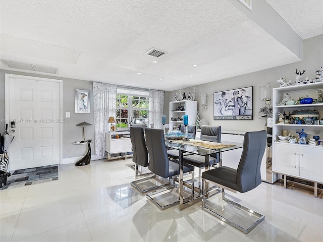 tiled dining room featuring a textured ceiling