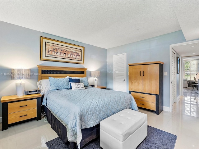 tiled bedroom featuring a textured ceiling