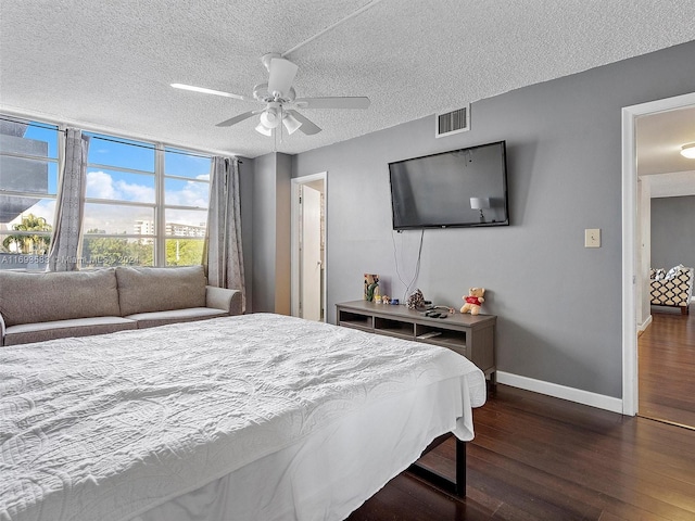 bedroom with ceiling fan, dark hardwood / wood-style floors, and a textured ceiling