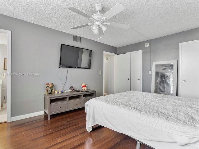 bedroom featuring ceiling fan, dark wood-type flooring, and a textured ceiling