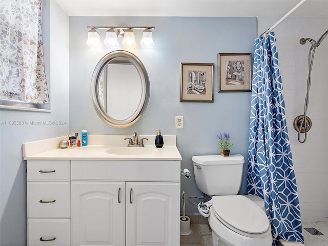 bathroom featuring tile patterned flooring, vanity, toilet, and curtained shower