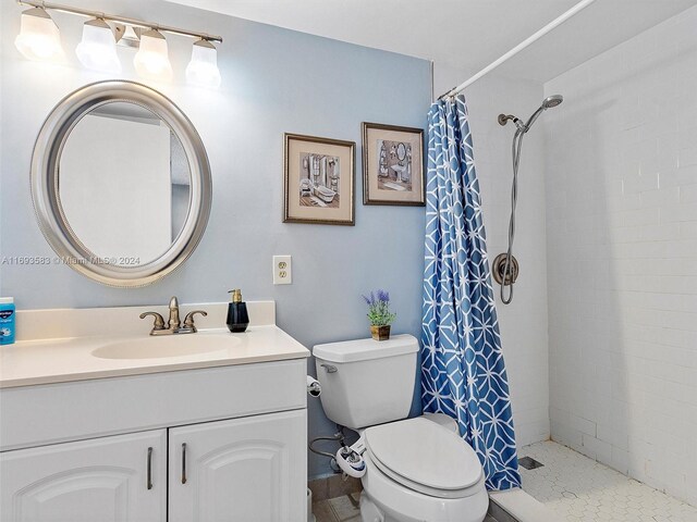 bathroom with vanity, toilet, tile patterned flooring, and a shower with shower curtain