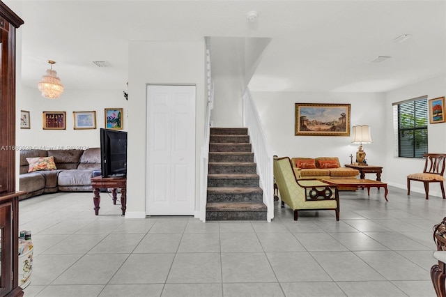 staircase with tile patterned flooring and a notable chandelier