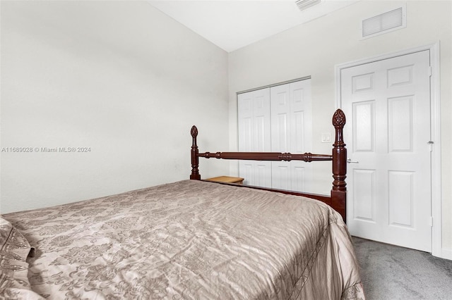 carpeted bedroom featuring vaulted ceiling and a closet