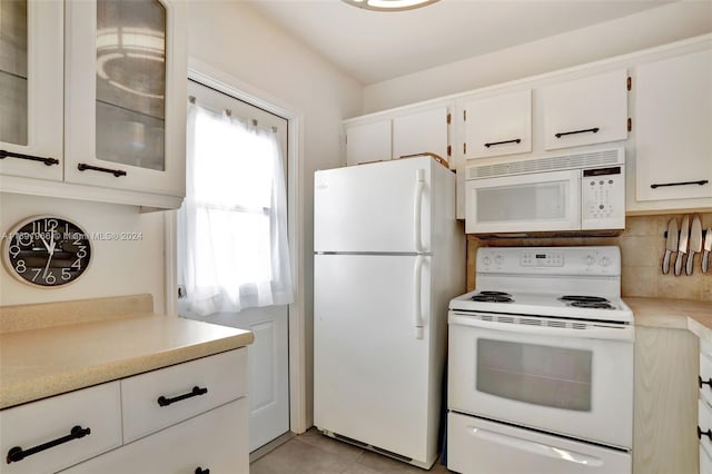 kitchen with white cabinets, white appliances, a healthy amount of sunlight, and backsplash