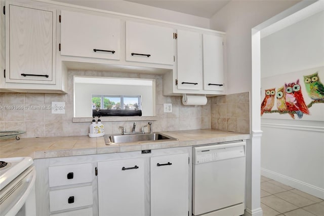 kitchen with sink, light tile patterned flooring, backsplash, white appliances, and white cabinets