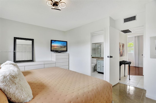 bedroom featuring ensuite bathroom and a textured ceiling