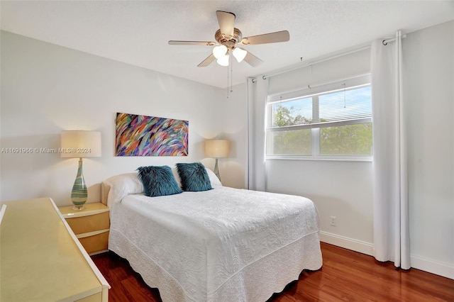 bedroom with ceiling fan and dark hardwood / wood-style flooring