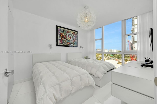 18201 Collins Ave Unit 1002, Sunny Isles Beach, FL 33160 - bedroom featuring a view of city, a chandelier, light tile patterned floors, and a wall of windows