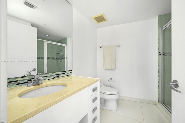 bathroom featuring tile patterned flooring, backsplash, an enclosed shower, toilet, and vanity