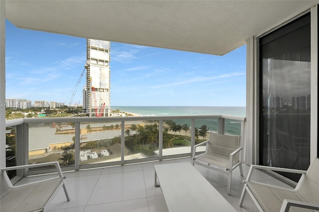 balcony with a water view and a beach view