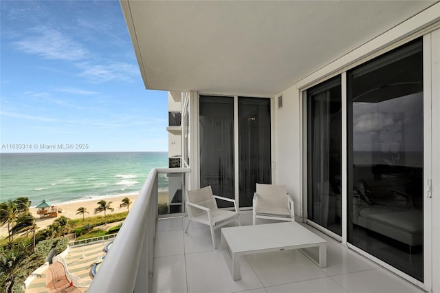 balcony with a water view and a beach view