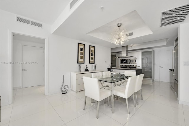 dining area featuring light tile patterned floors and a tray ceiling