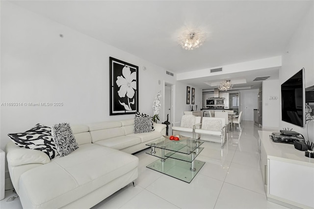 tiled living room featuring an inviting chandelier