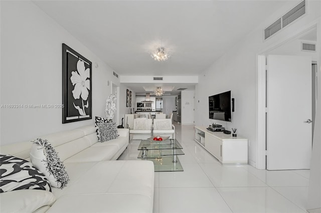 living room featuring a notable chandelier and light tile patterned flooring