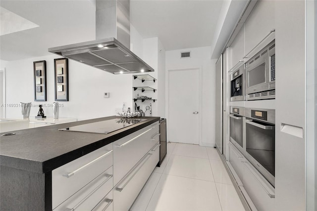 kitchen with light tile patterned floors, island exhaust hood, and appliances with stainless steel finishes