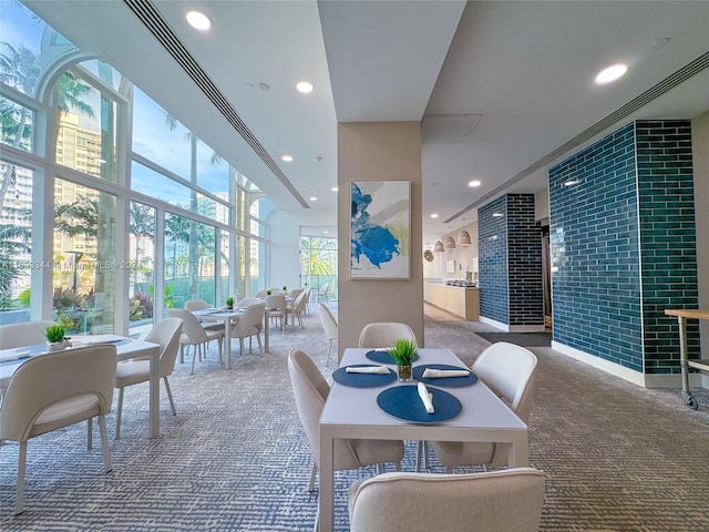 carpeted dining space featuring brick wall