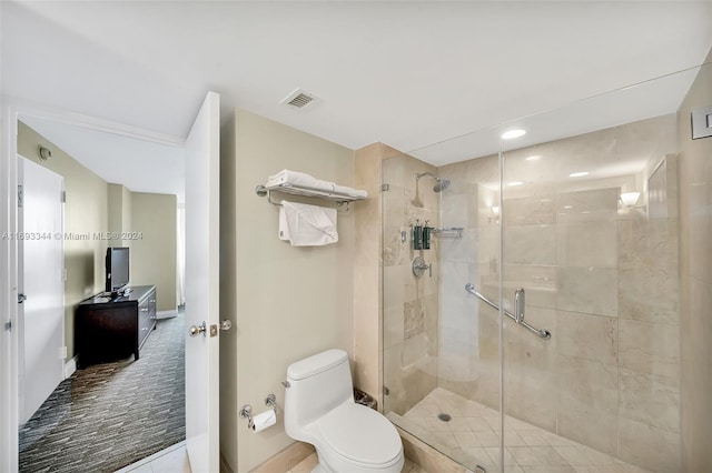 bathroom featuring toilet and a shower with shower door