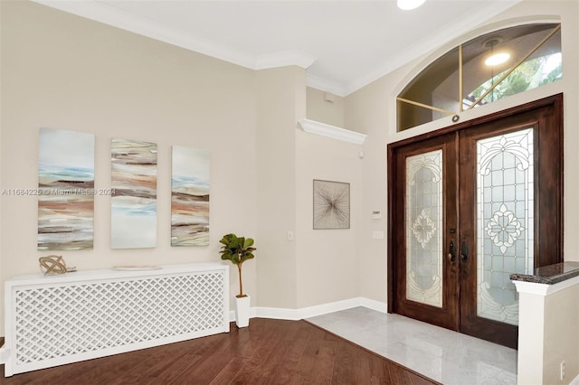 entryway with radiator, crown molding, french doors, and hardwood / wood-style floors