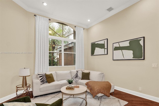 living area with hardwood / wood-style flooring and crown molding