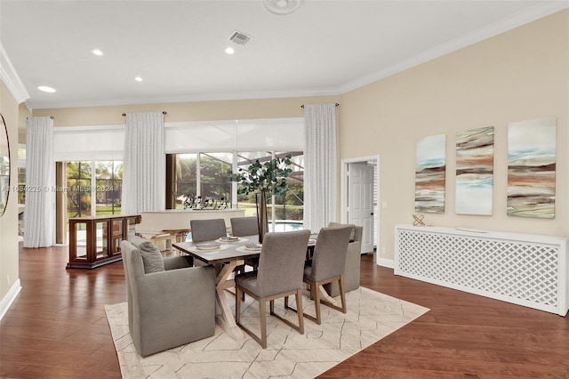 dining space with crown molding and wood-type flooring