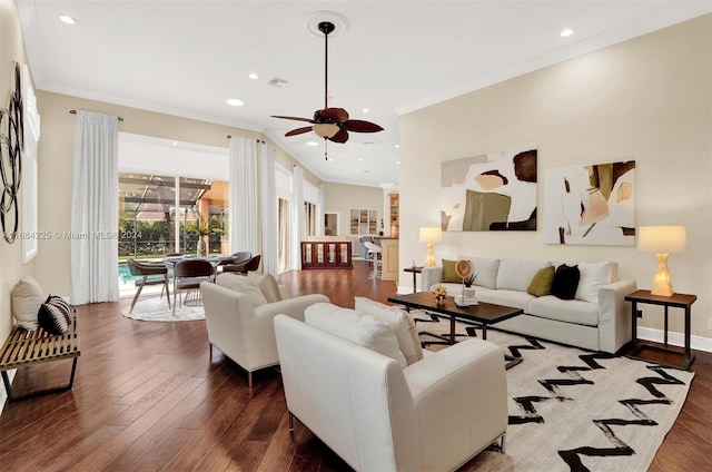 living room with crown molding, ceiling fan, and dark wood-type flooring