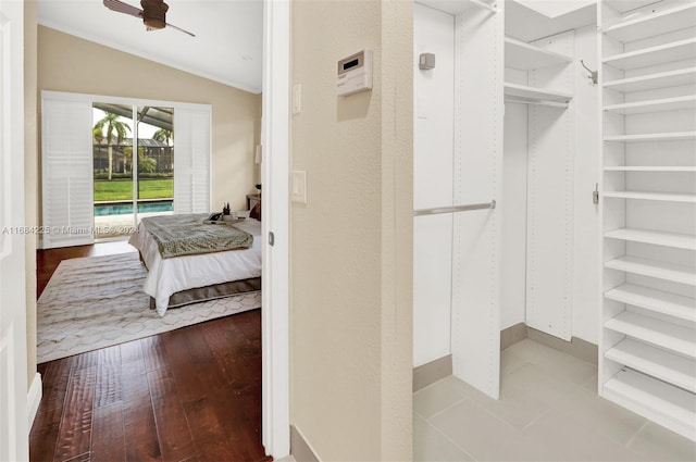 spacious closet with ceiling fan, wood-type flooring, and lofted ceiling