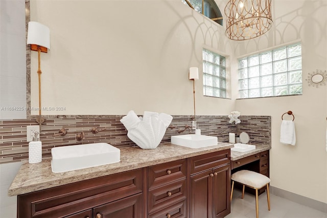 bathroom featuring vanity, a chandelier, backsplash, and tile patterned flooring