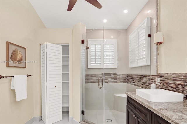 bathroom featuring vanity, tasteful backsplash, an enclosed shower, and ceiling fan